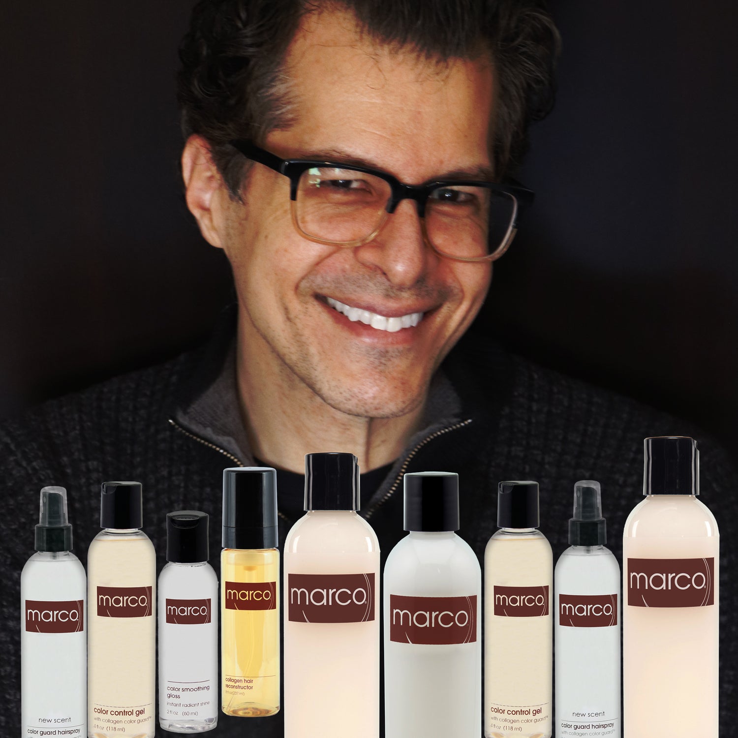 Marco Pelusi, dark hair, glasses, smiles behind his full collection of collagen hair care products